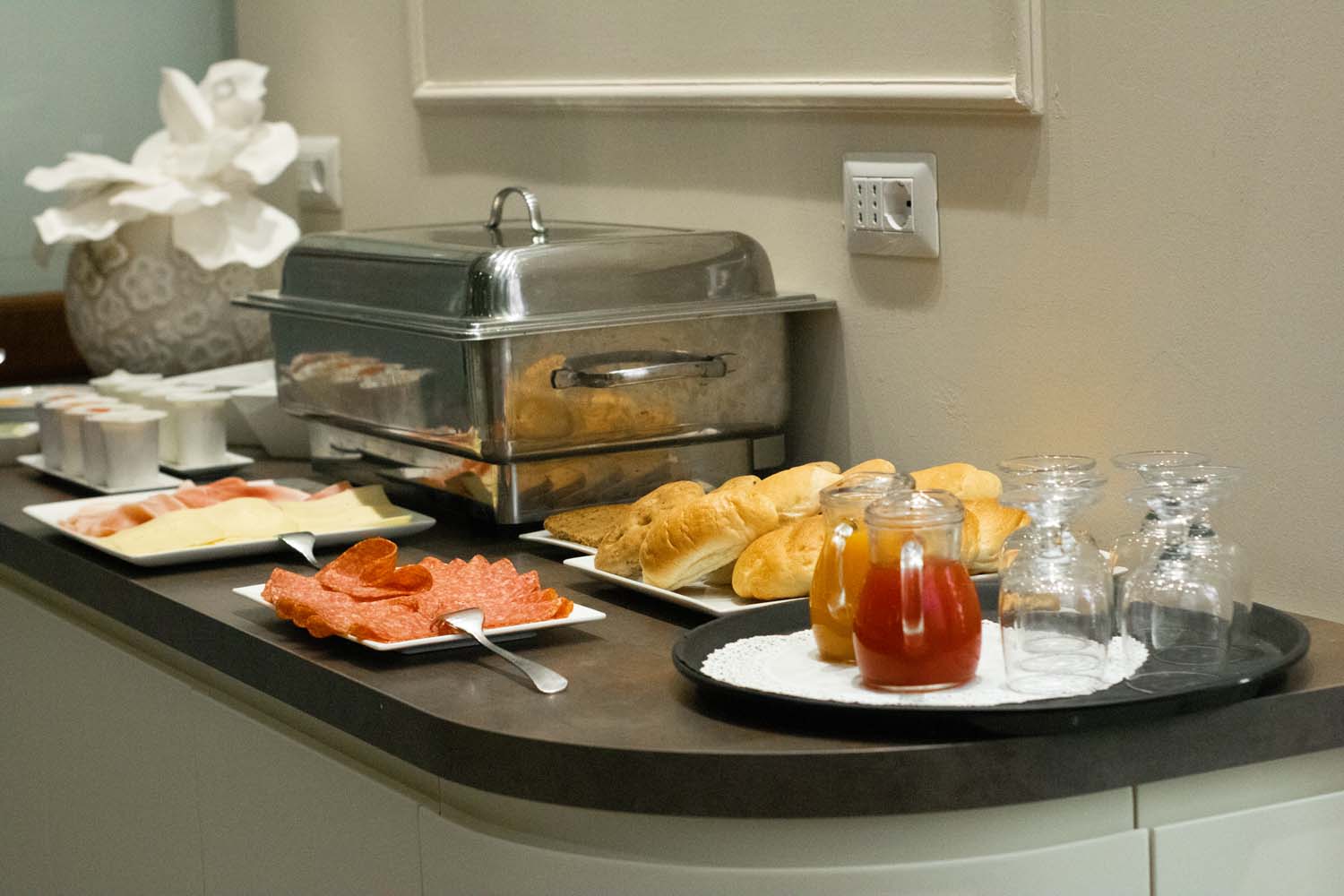 Il buffet della colazione con i piatti caldi e il pane